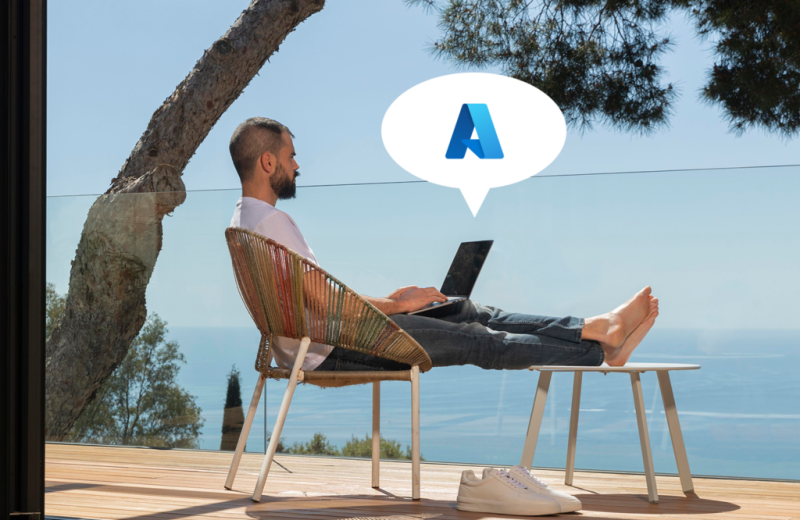 Person mit Laptop auf Terrasse am Meer