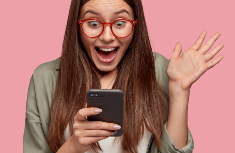 Überraschte Frau mit Smartphone