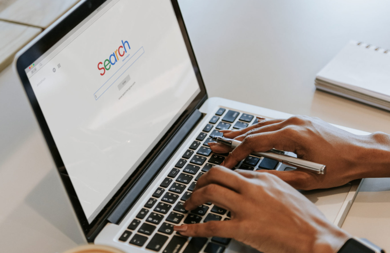 Hände tippen am Laptop mit Suchmaschine
